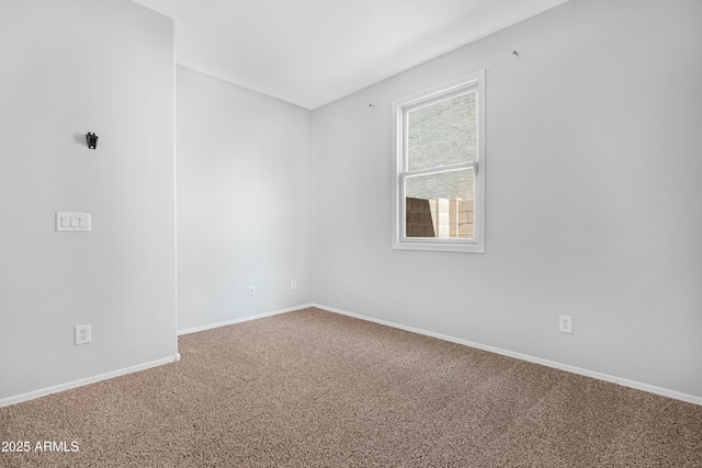 spare room featuring carpet and baseboards