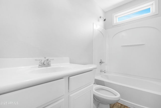 full bath with vanity, wood finished floors, washtub / shower combination, and toilet