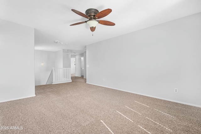 carpeted empty room with baseboards and a ceiling fan