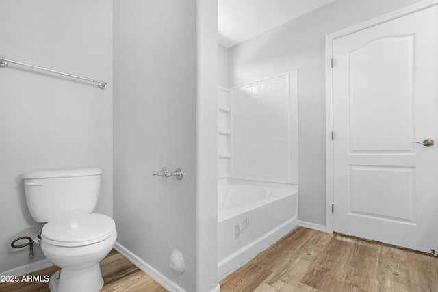 bathroom featuring toilet, baseboards, and wood finished floors