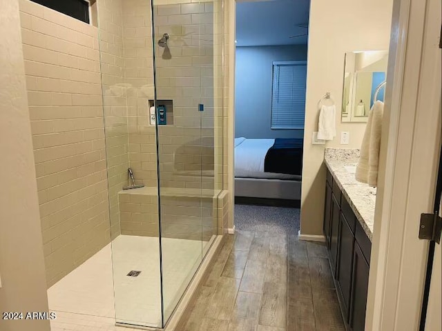 bathroom with a tile shower, vanity, and hardwood / wood-style flooring