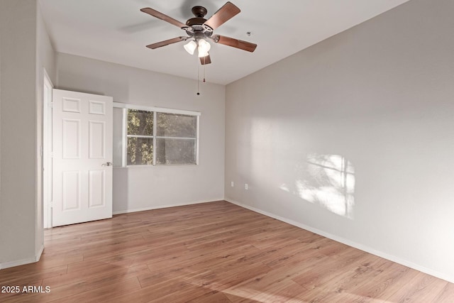 spare room with a ceiling fan, wood finished floors, and baseboards