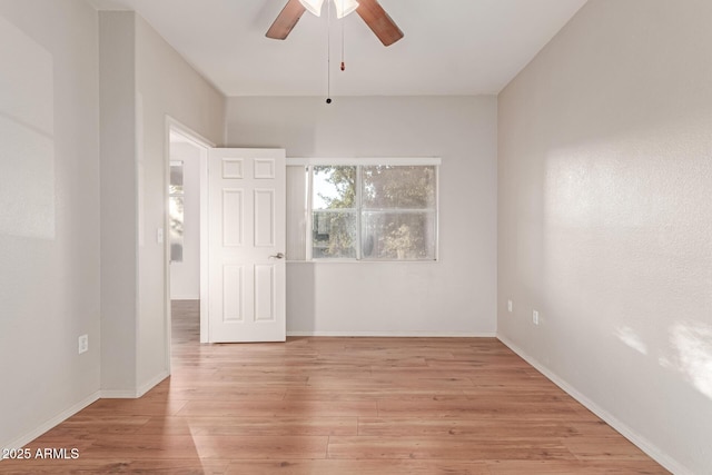 spare room featuring light wood-style flooring, baseboards, and ceiling fan