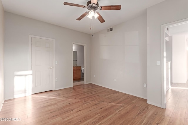 unfurnished bedroom with light wood-type flooring, lofted ceiling, visible vents, and connected bathroom