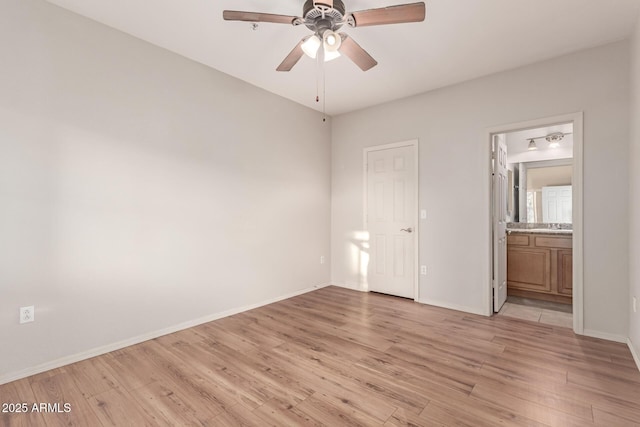 unfurnished bedroom featuring light wood-style flooring, baseboards, ensuite bathroom, and ceiling fan