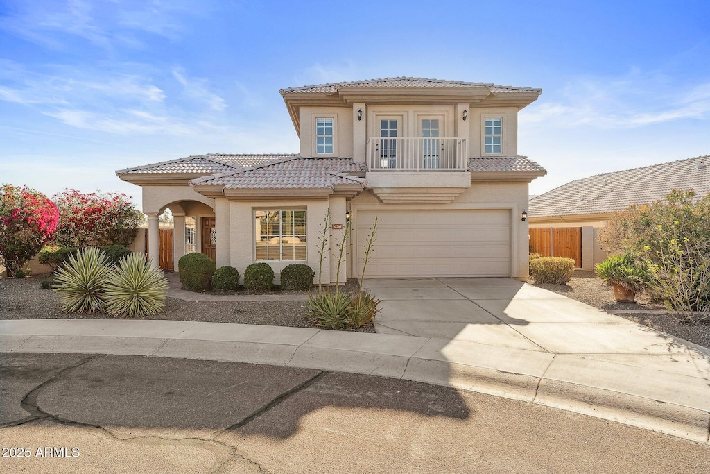 mediterranean / spanish home with a garage, french doors, and a balcony