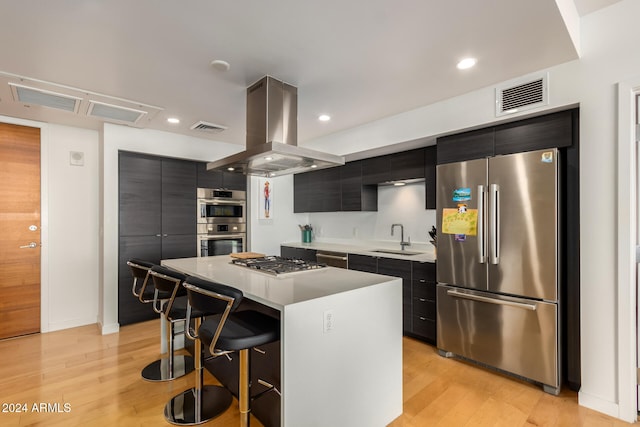 kitchen featuring appliances with stainless steel finishes, sink, a breakfast bar area, island exhaust hood, and a center island