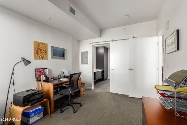 carpeted office with a barn door and electric panel