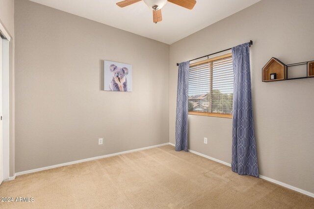 unfurnished room featuring ceiling fan and light colored carpet