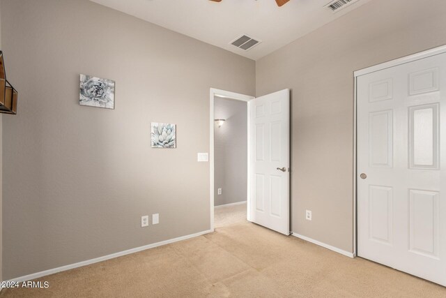 unfurnished bedroom with light carpet and ceiling fan