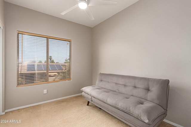 living area with light colored carpet and ceiling fan