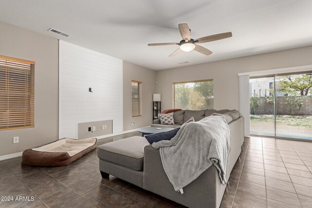 living room featuring dark tile patterned flooring and ceiling fan