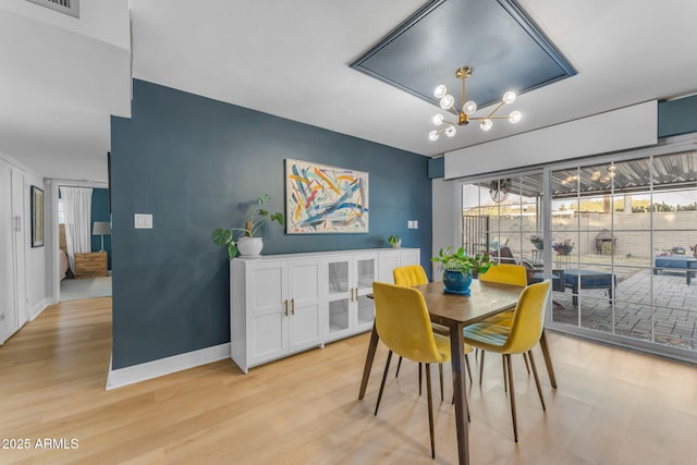 dining room with an inviting chandelier and light hardwood / wood-style flooring