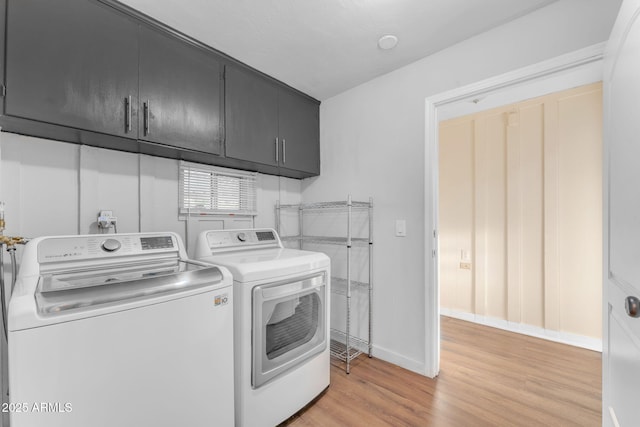 laundry room featuring cabinets, separate washer and dryer, and light hardwood / wood-style floors