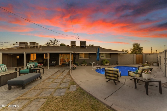 pool at dusk featuring central AC unit, outdoor lounge area, and a patio