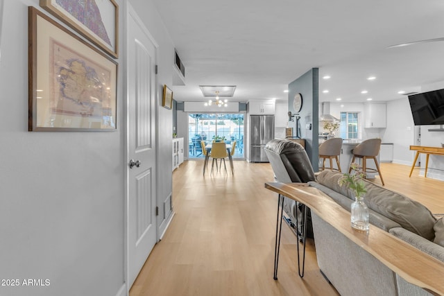 living room with a healthy amount of sunlight and light hardwood / wood-style flooring