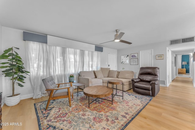 living room with wood-type flooring and ceiling fan