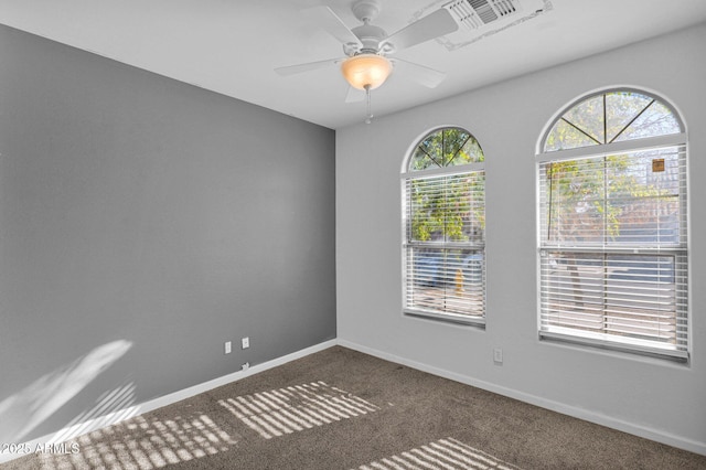 empty room featuring ceiling fan and dark carpet