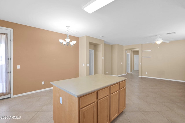 kitchen featuring pendant lighting, ceiling fan with notable chandelier, light tile patterned flooring, and a kitchen island