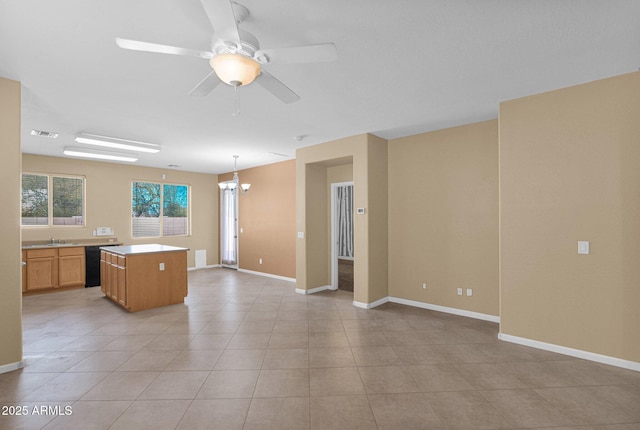 kitchen featuring dishwasher, a kitchen island, decorative light fixtures, light tile patterned flooring, and ceiling fan with notable chandelier