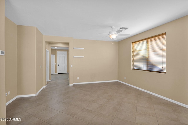 tiled spare room featuring ceiling fan