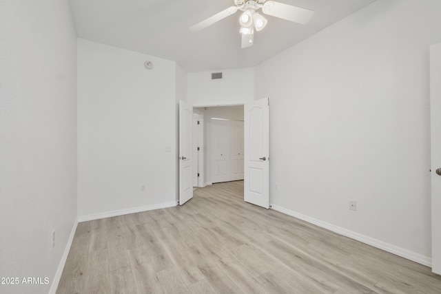 spare room with ceiling fan, light wood-type flooring, visible vents, and baseboards