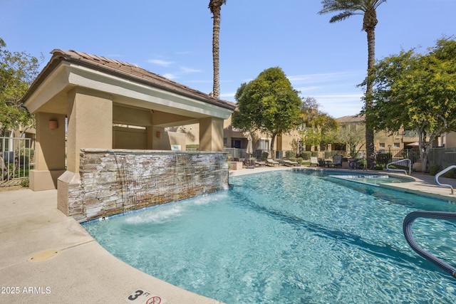 community pool featuring a patio area and fence