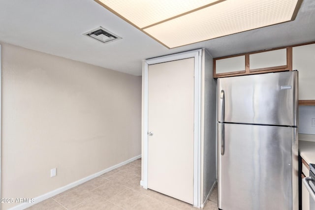 kitchen featuring light tile patterned flooring and stainless steel fridge