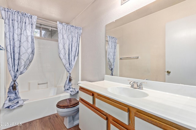 full bathroom featuring hardwood / wood-style flooring, vanity, shower / bath combo with shower curtain, and toilet