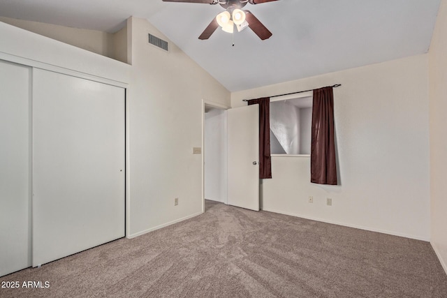 unfurnished bedroom with lofted ceiling, light carpet, a closet, and ceiling fan