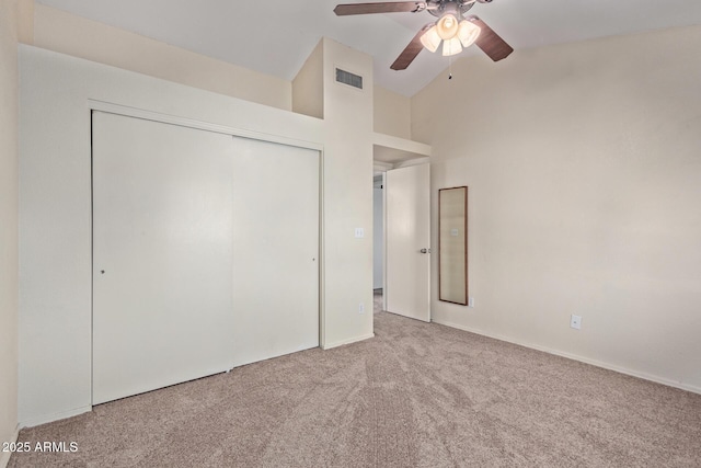 unfurnished bedroom with carpet floors, high vaulted ceiling, a closet, and ceiling fan