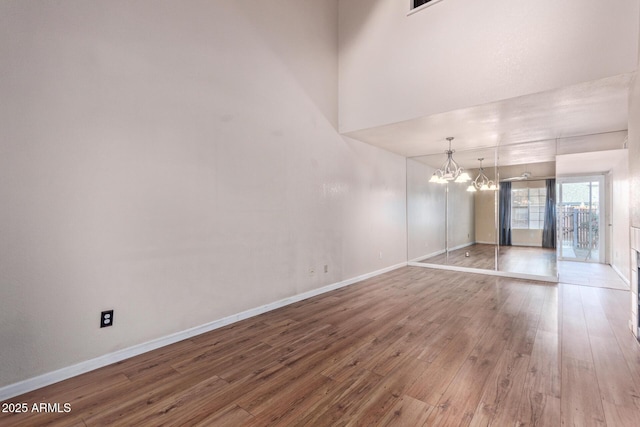 empty room featuring hardwood / wood-style floors and an inviting chandelier