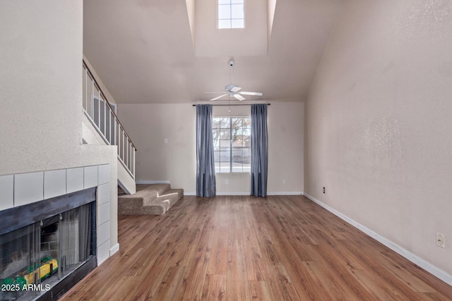 unfurnished living room featuring a fireplace, ceiling fan, and light hardwood / wood-style flooring