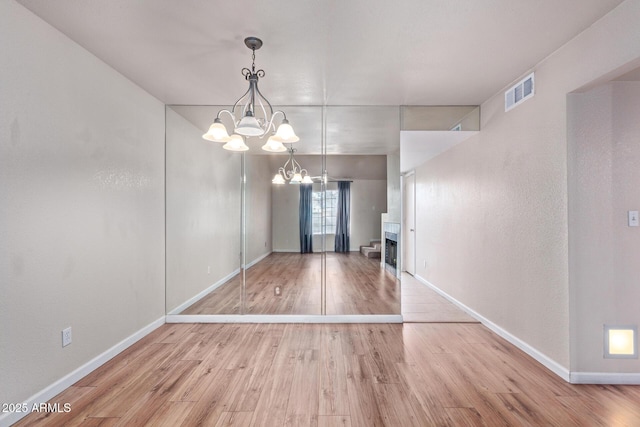 interior space with a notable chandelier and light hardwood / wood-style floors