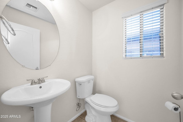 bathroom with toilet and tile patterned flooring