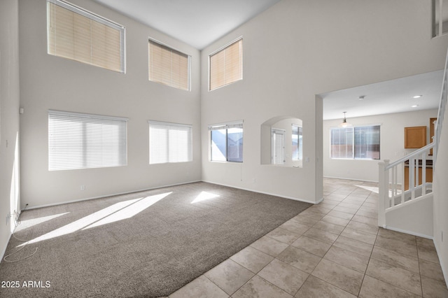 carpeted spare room with a high ceiling