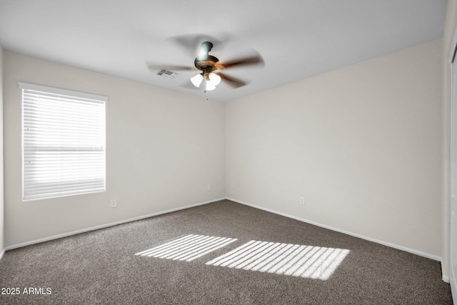 unfurnished room with dark carpet and ceiling fan