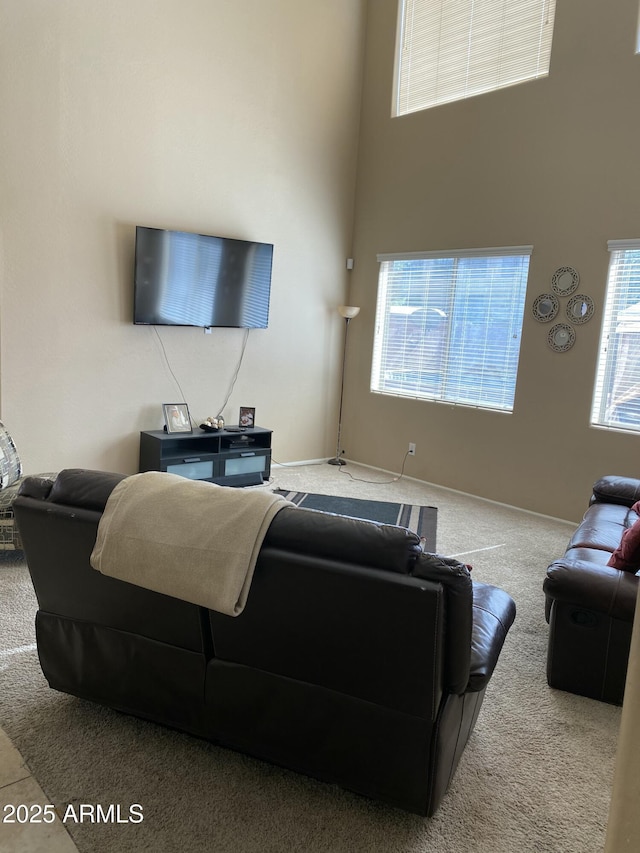 carpeted living room with a high ceiling