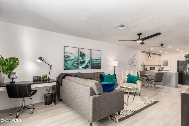 living room featuring ceiling fan and light wood-type flooring