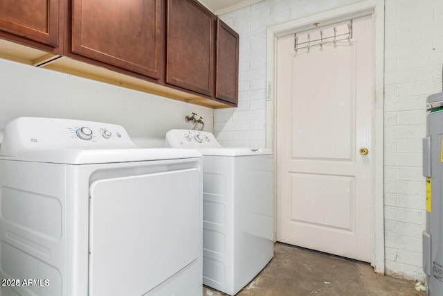 laundry area featuring cabinets, separate washer and dryer, and water heater