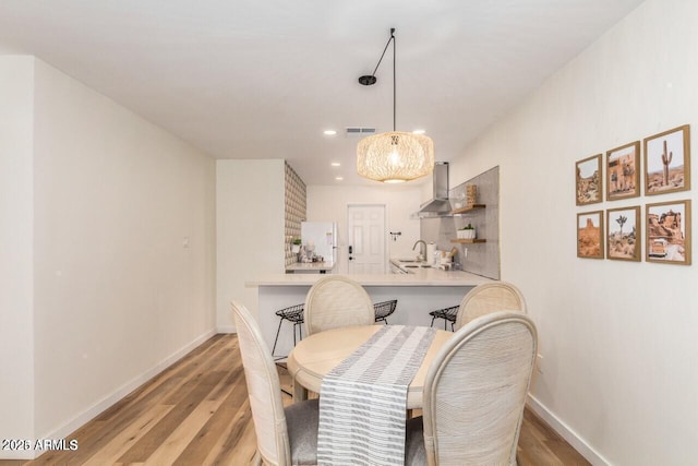 dining area with sink and light hardwood / wood-style flooring