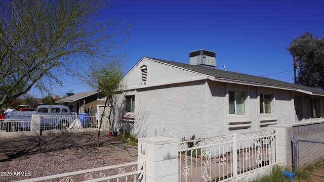 view of front of house with cooling unit, fence, and stucco siding