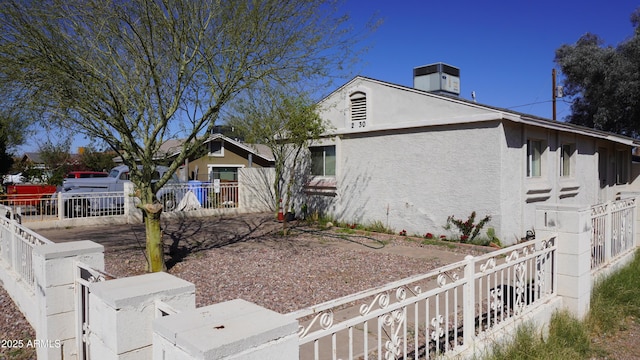 view of home's exterior with stucco siding and fence private yard