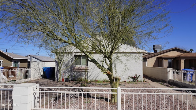 view of front of home with a fenced front yard and cooling unit