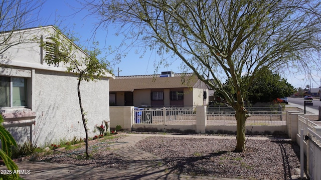 rear view of property with a fenced front yard and stucco siding