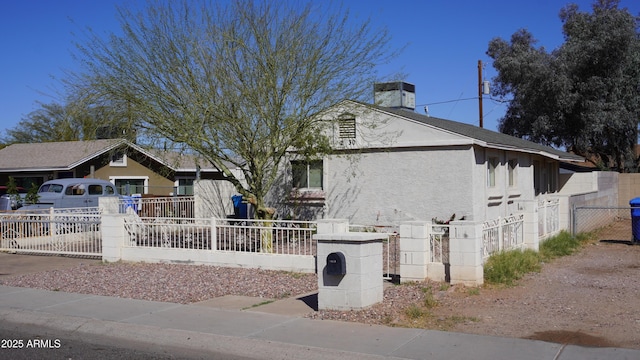 view of front of home with a fenced front yard and stucco siding