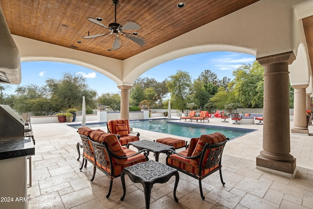 view of patio / terrace featuring ceiling fan, exterior kitchen, and a fenced in pool