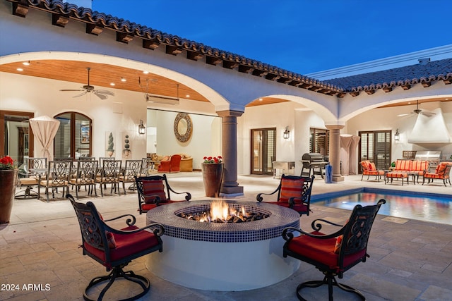 view of patio featuring ceiling fan and an outdoor fire pit