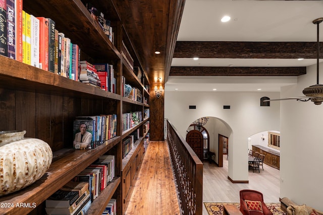 hallway featuring beam ceiling and light wood-type flooring