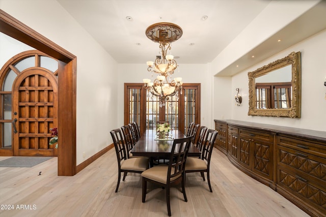 dining room with plenty of natural light, light hardwood / wood-style flooring, and a notable chandelier